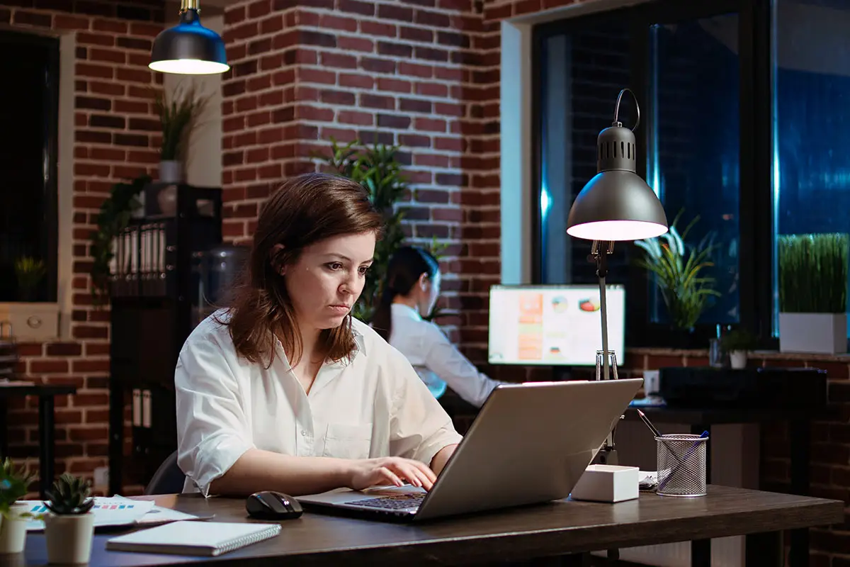 Woman working on laptop illustrating website redesign and digital marketing strategy.