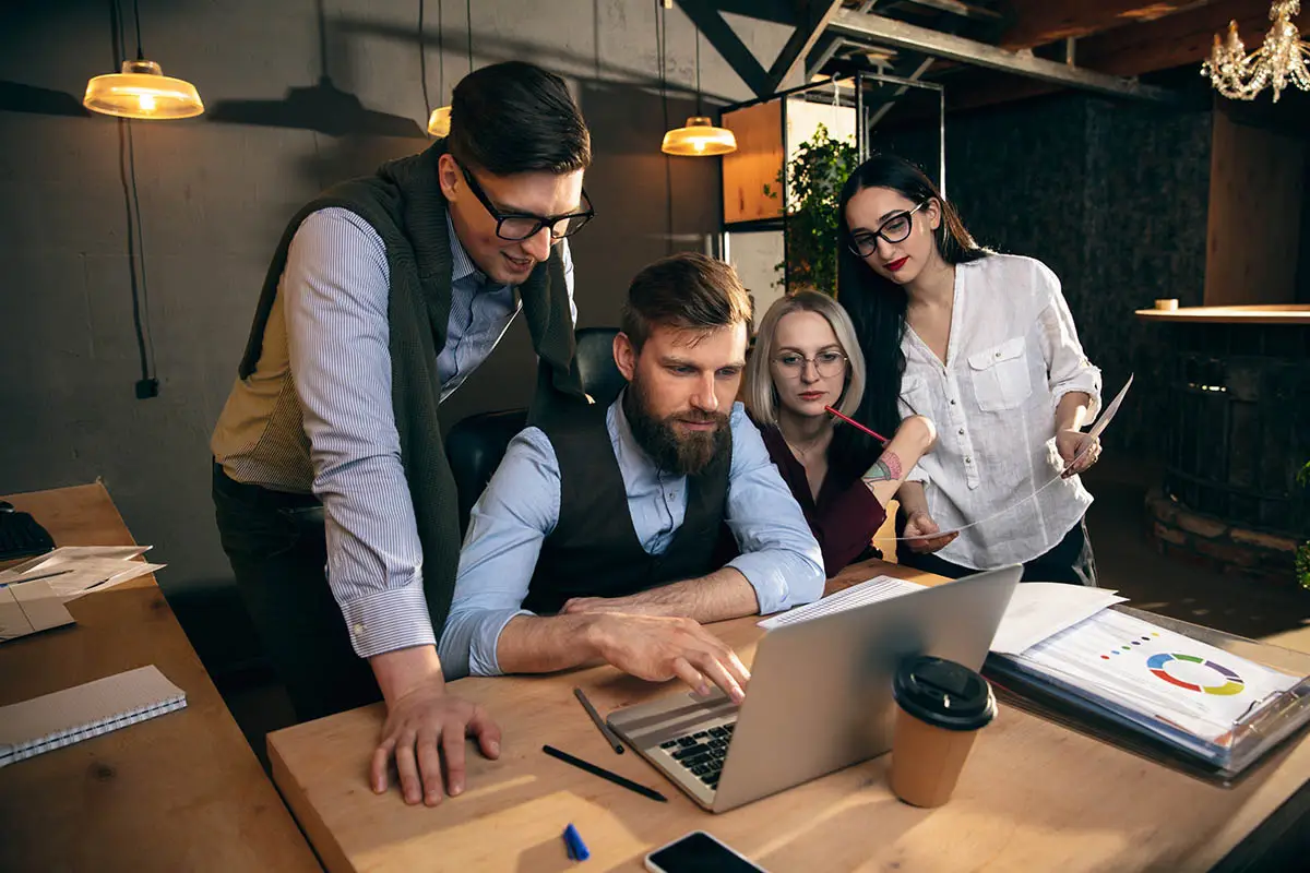 IT project team collaborating on laptop, Quantum Shield IT content creation success story.