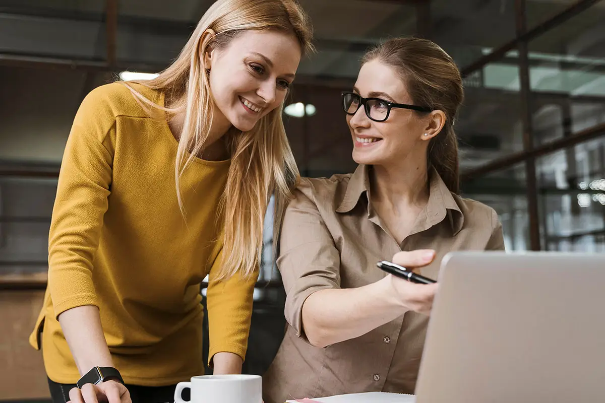 Two women collaborating on social media project, Quantum Shield IT solutions.